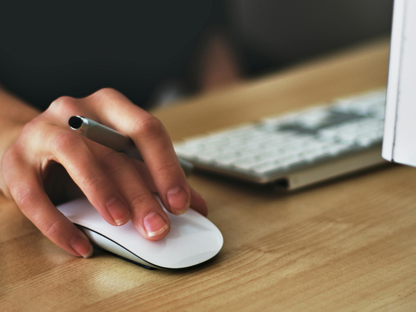 Eine Detailaufnahme einer Hand die eine Computermouse bedient.